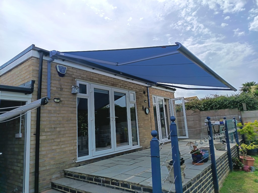 Denim fabric Weinor Cassita II fully projected over a stone patio on a single-storey home in Loose