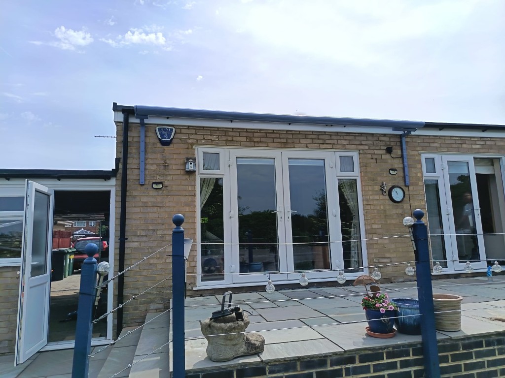Pigeon Blue Weinor Cassita II cassette retracted on specialist tall brackets above patio doors in Loose
