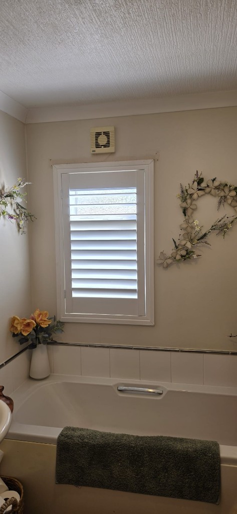Moisture-resistant white shutters with 76mm louvres in a Margate caravan bathroom