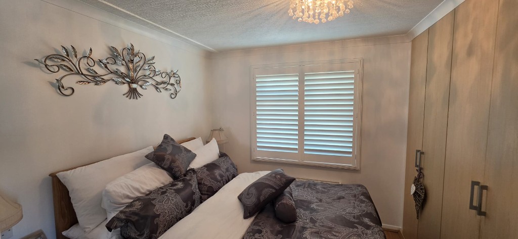 Bedroom shutters recessed in window frame with built-in wardrobes, Margate caravan