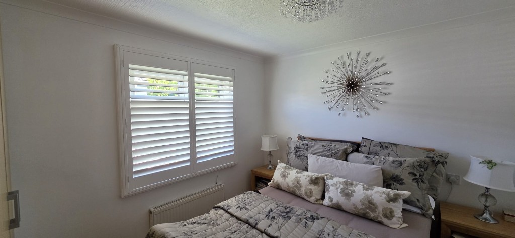 Bedroom window fitted with pure white 76mm louvre shutters in a static caravan, Margate Kent