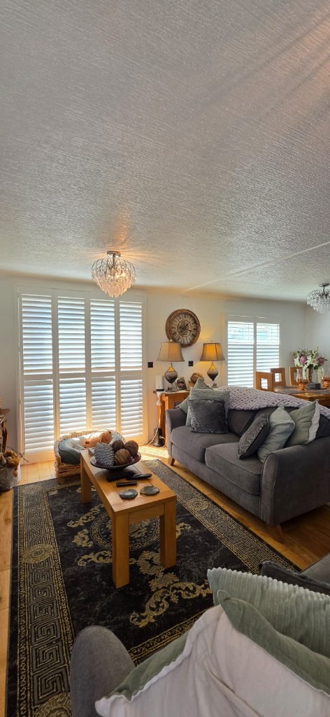 Full-height white shutters on patio doors and windows in a Margate static caravan lounge