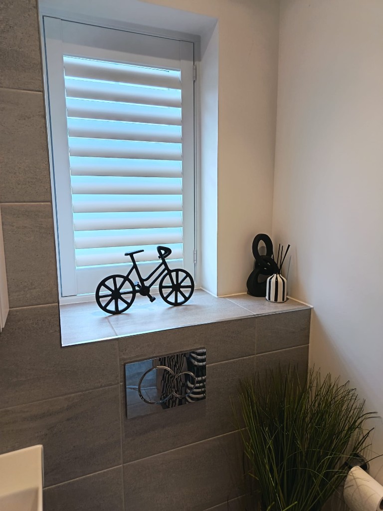 Moisture-resistant Polylite shutters in pure white with 76mm louvres in a Snodland bathroom