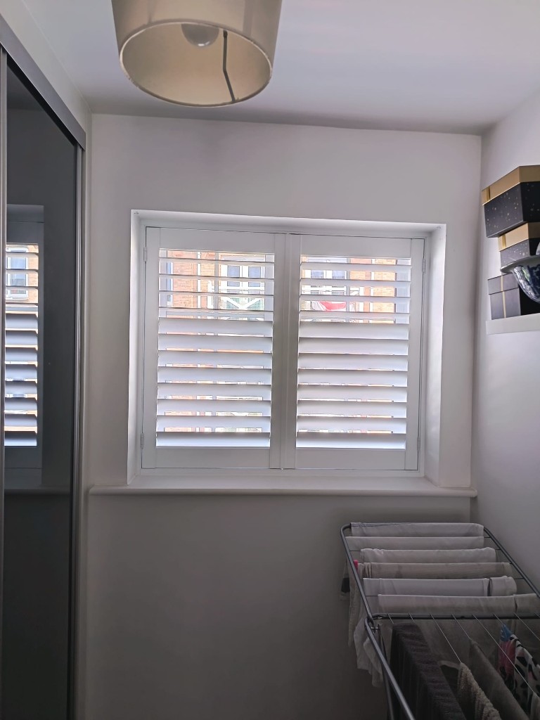 Two-panel pure white Polylite shutters with 76mm louvres fitted in a Snodland bedroom