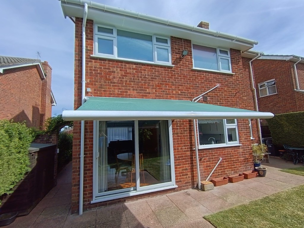 Weinor Cassita II awning shading white patio doors on a brick home in Loose, Kent
